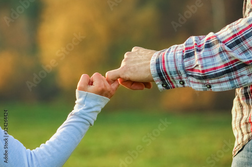 a beautiful hands of parent and child outdoors in the park