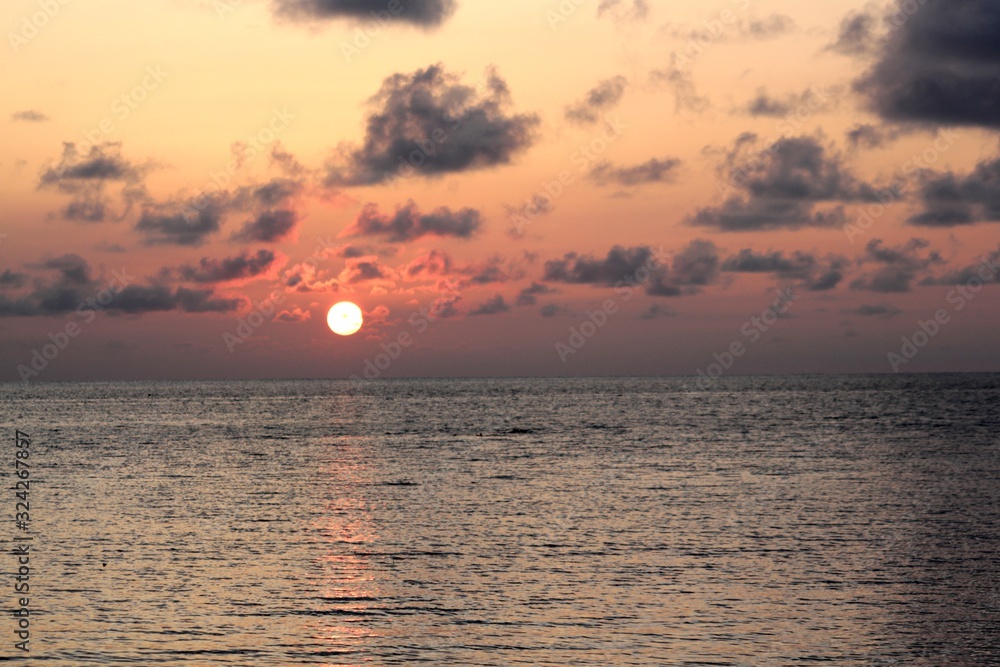 Wide shot of a beautiful sunset reflected in the waters of Saipan lagoon