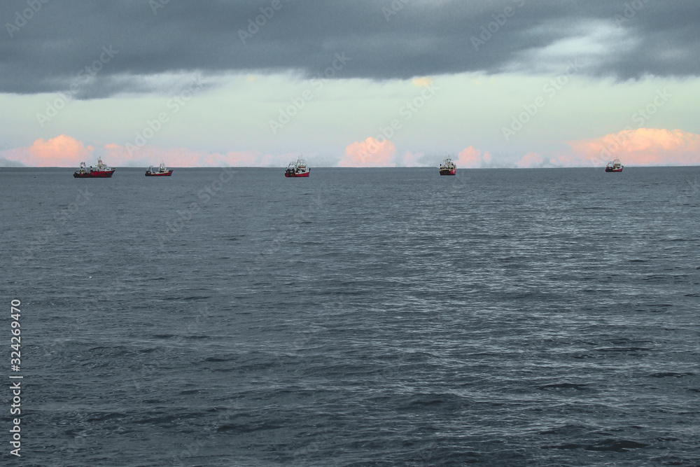 Barcos de pesca en el horizonte al atarceder