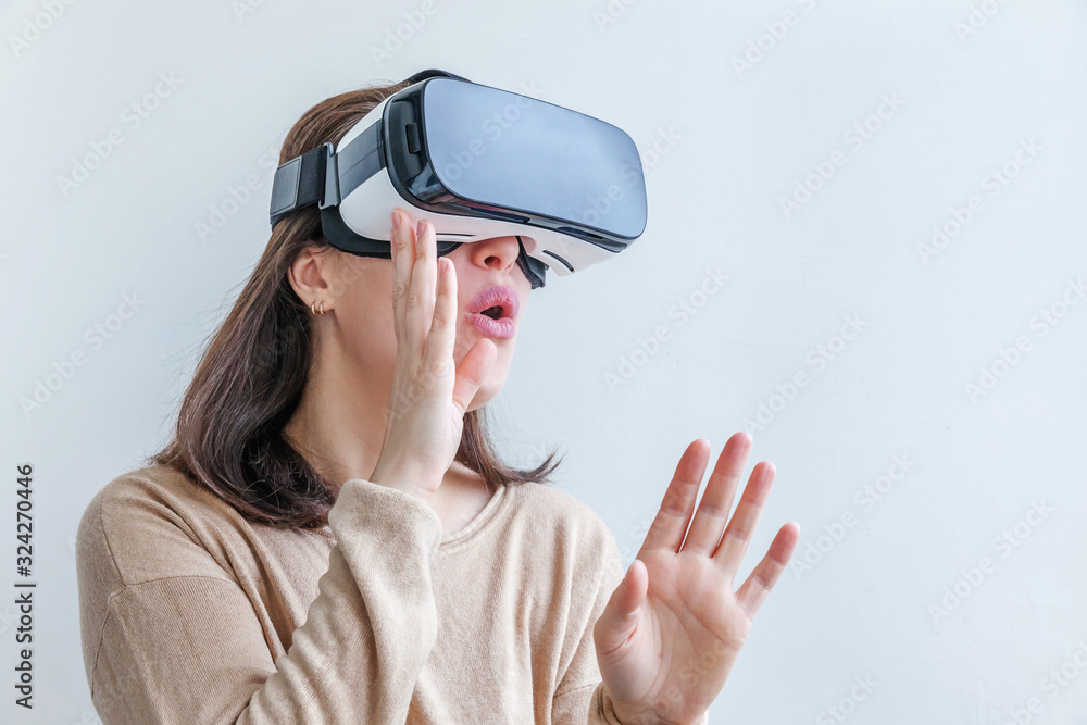 Smile young woman wearing using virtual reality VR glasses helmet headset on white background. Smartphone using with virtual reality goggles. Technology, simulation, hi-tech, videogame concept. Smile young woman wearing using virtual reality VR glasses helmet headset on white background. Smartphone using with virtual reality goggles. Technology, simulation, hi-tech, videogame concept.