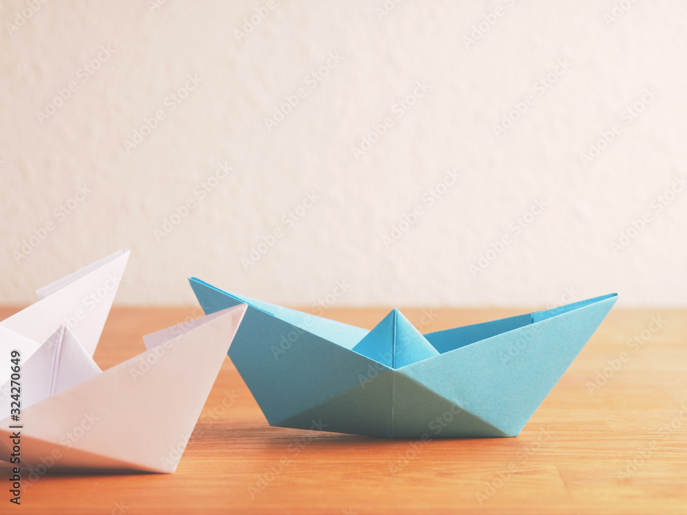Naklejka premium Teamwork business concept with paper boat on a wooden table