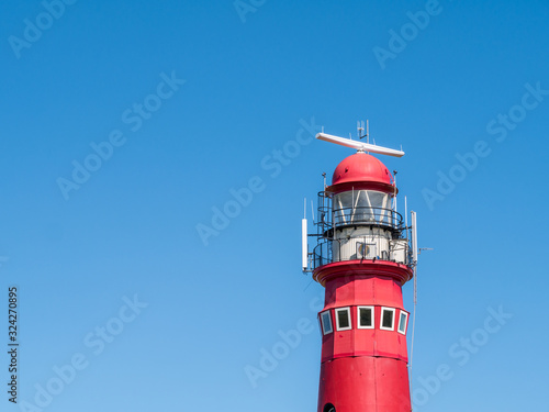 Top of red North Tower lighthouse against blue sky, Frisian island Schiermonnikoog, Netherlands photo