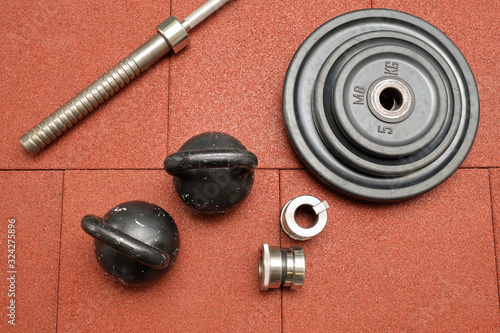 Dumbbells and kettlebells on a floor. Bodybuilding equipment. Fitness or bodybuilding concept background. Photograph taken from above, top view