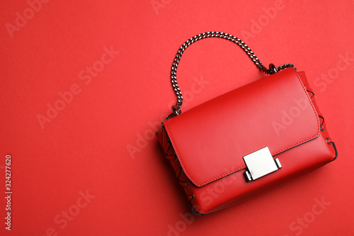 Stylish woman's bag on red background, top view. Space for text photo