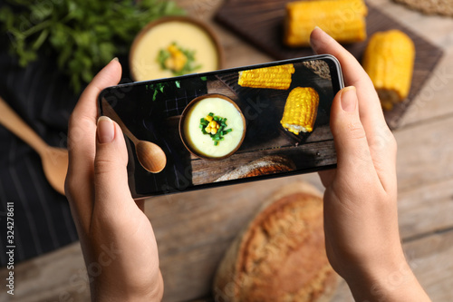 Fototapeta Naklejka Na Ścianę i Meble -  Blogger taking photo of dinner at table, closeup