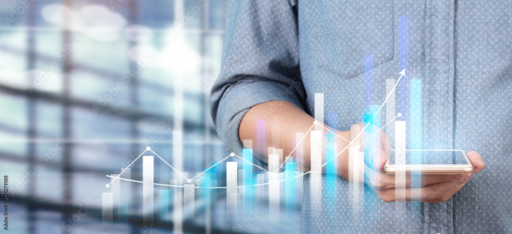 Hand holding smartphone device and touching screen. Stock exchange market concept Hand holding smartphone device and touching screen. Stock exchange market concept