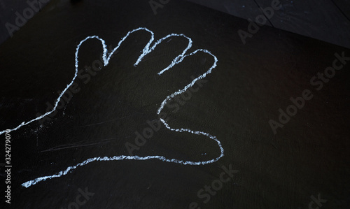 palm contour drawn in chalk on a black chalkboard.