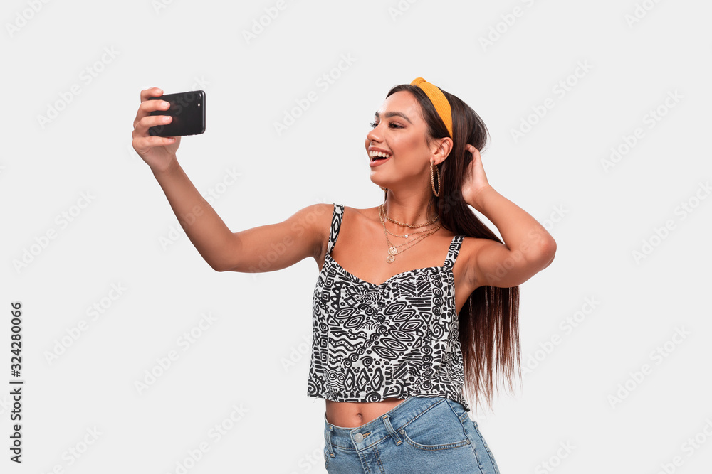 Pretty african-american teenager making selfie with a smartphone. Pretty african-american teenager making selfie with a smartphone.