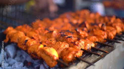 Paneer fish chicken tikka roasting on an open hearth with glowing coals and smoke coming out