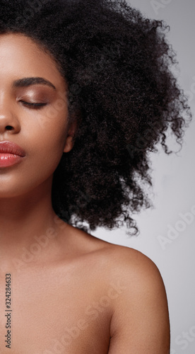 Young African American female model with soft makeup and naked shoulders