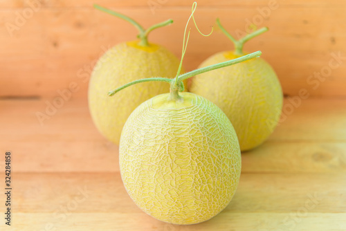 Fresh yeloow galia melon on wood plate photo