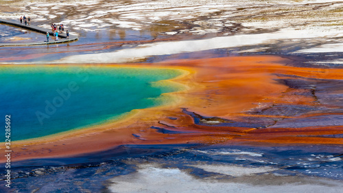 A view of a section of the Grand Prismatic Spring in Yellowstone National Park with tourists on the boardwalk