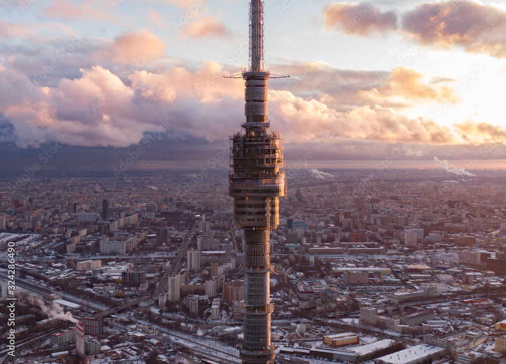 Ostankino television tower against the background of the winter city of Moscow from above, in the frame a winter city and streets, aerial photo