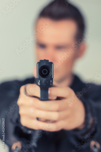 Close-up of man aiming with handgun.