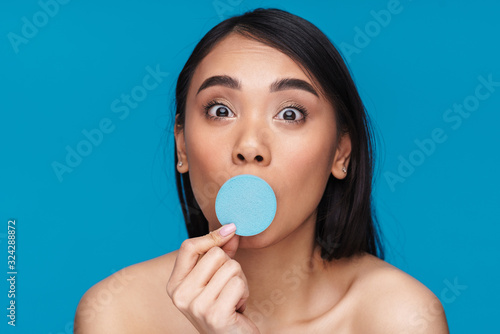 Woman posing isolated with skin cleansing sponge.