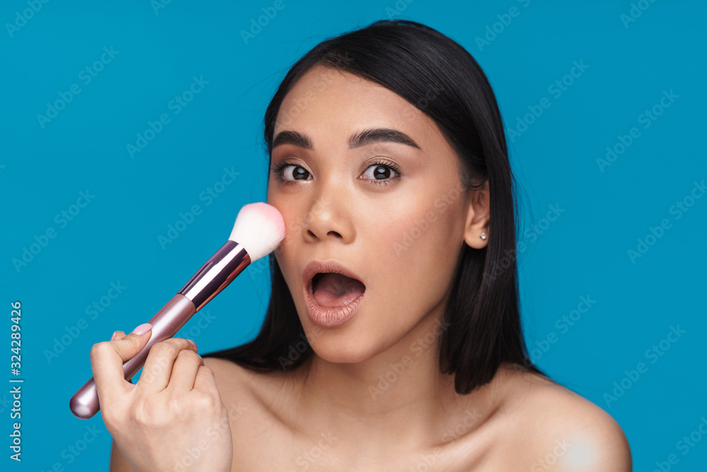 Woman posing isolated apply powder with brush. Woman posing isolated apply powder with brush.