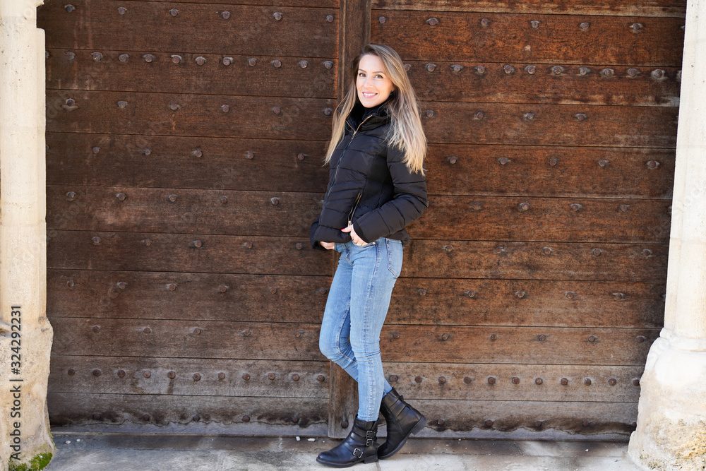 Full length portrait of young beautiful slim woman on wood ancient door background in city Full length portrait of young beautiful slim woman on wood ancient door background in city