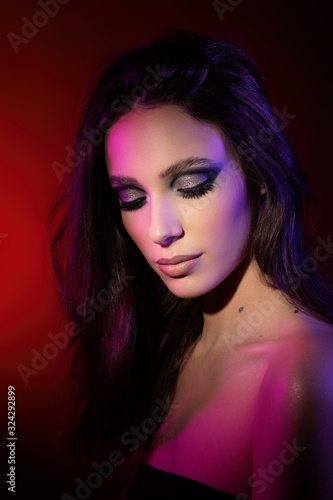 Colorful portrait of an attractive young woman under red background