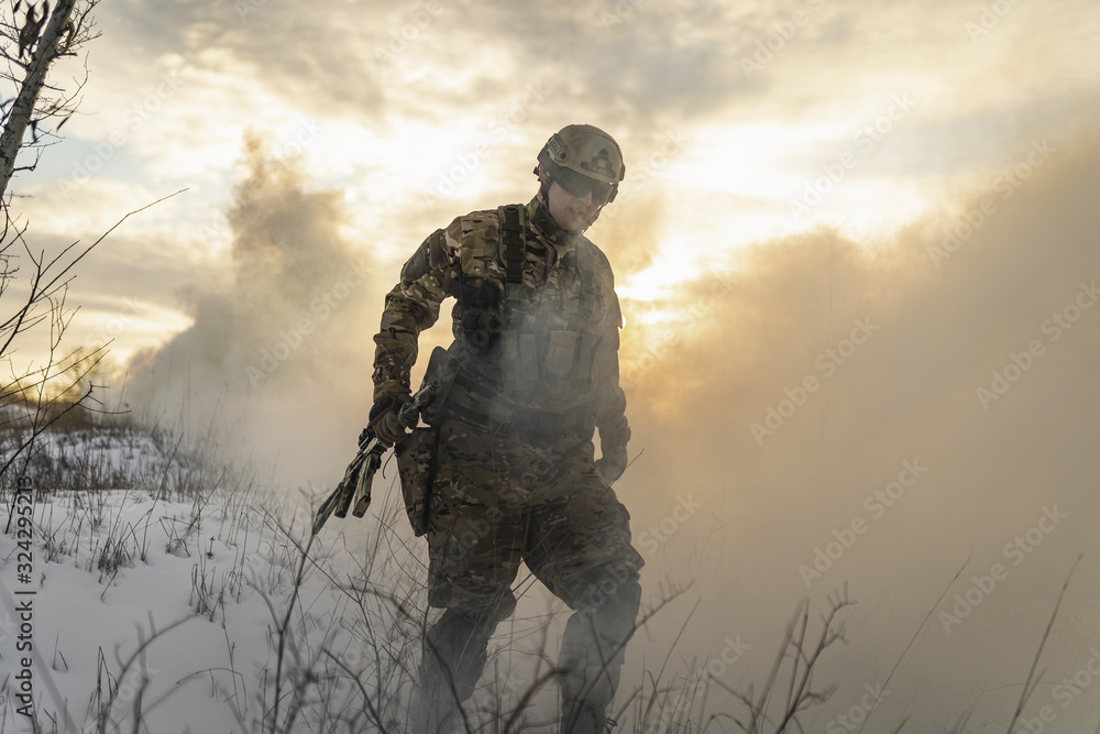 equipped army soldier Man in the winter khaki camouflage is patrolling or patrol field territory. commandos with full equipment helmet and gun watch battlefield. Modern army soldier