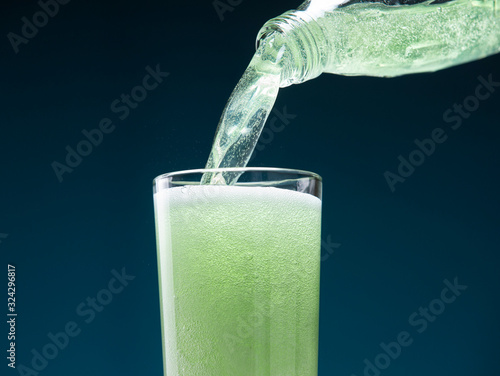 Fotografie Mojito carbonated cocktail pours from a bottle into a glass