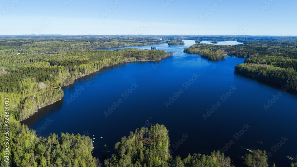 Blue lake, islands and green forests from above on a sunny summer day. Lake landscape in Finland. Blue lake, islands and green forests from above on a sunny summer day. Lake landscape in Finland.