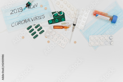 Surgical mask protective mask with CORONAVIRUS text. Virus 2019-n CoV in Wuhan, China. Tablets, mask, syringe