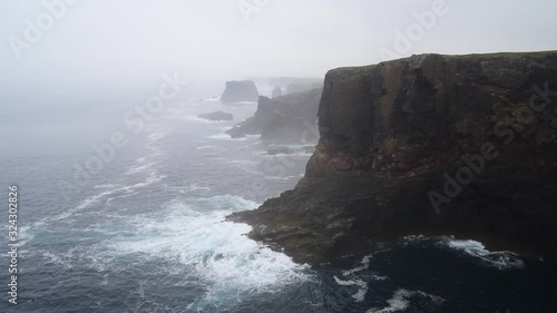 Sea stacks and cliffs in the mist at Eshaness / Esha Ness, peninsula in Northmavine on the island of Mainland, Shetland Islands, Scotland, UK photo