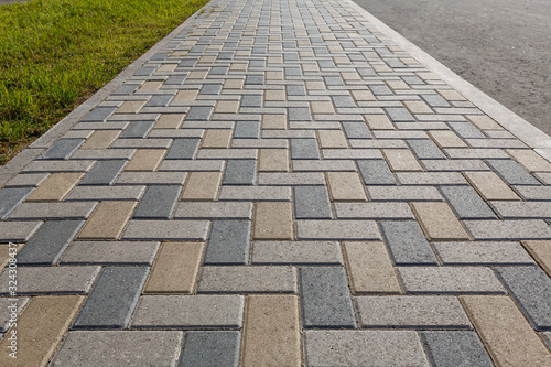 Foto Colorful cobblestone road pavement and lawn divided by a concrete curb