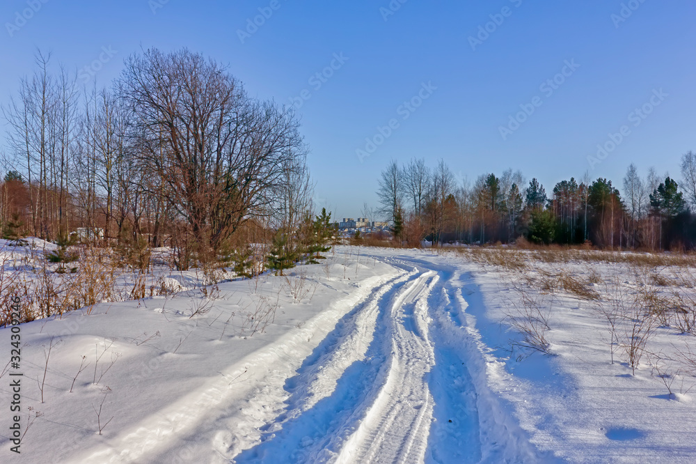Winter landscape road in the forest on a sunny day. Winter landscape road in the forest on a sunny day.