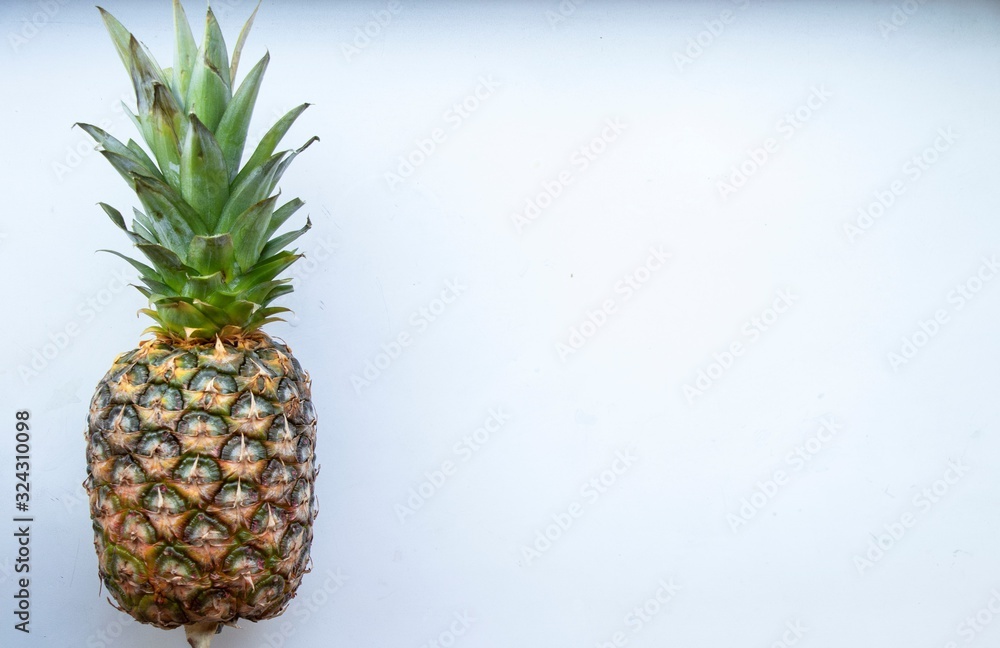 Big pineapple on a turquoise background. Juicy fruit - summer mood with bright colors. On white background. Big pineapple on a turquoise background. Juicy fruit - summer mood with bright colors. On white background.