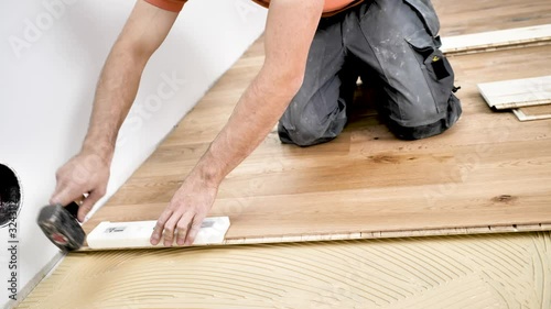 Handwerker verlegt holzboden Parkett in einem modernem haus. 4k Video in zeitlupe