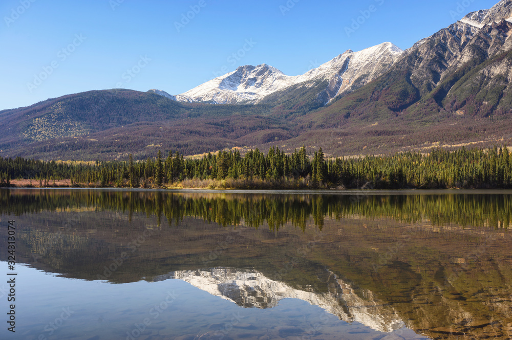 Mountain range with pine forest reflection on Pyramid Lake at Jasper national park