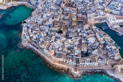 Italy, Apulia, Monopoli, Aerial view of sea and old town at sunset photo