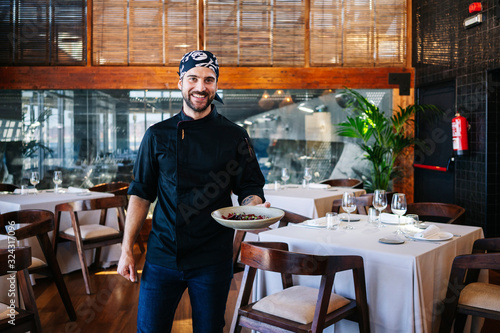 Portrait of smiling man serving a dish in restaurant photo