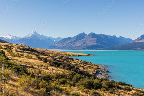 New Zealand, Clear sky over turquoise shore of Lake†Pukaki†with Mount Cook looming in background photo