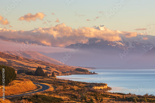 New Zealand, Scenic view of New†Zealand†State Highway 80 stretching along shore of Lake†Pukaki†at dawn with Mount Cook in background photo