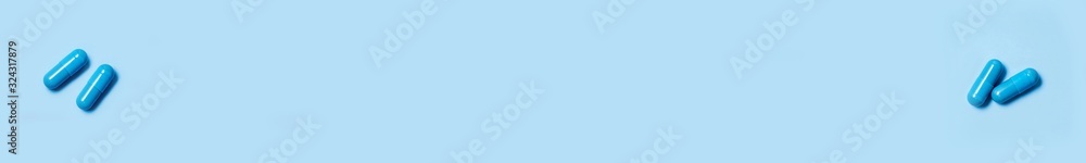 Banner. Two blue capsules. Pills for men's health and sexual energy on an isolated background. Concept of erection, potency. Treatment of male infertility and impotence. Copy space Banner. Two blue capsules. Pills for men's health and sexual energy on an isolated background. Concept of erection, potency. Treatment of male infertility and impotence. Copy space