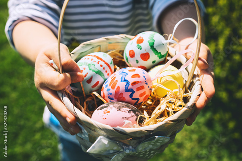 Colorful Easter eggs in basket. Kids hunt for eggs outdoors.