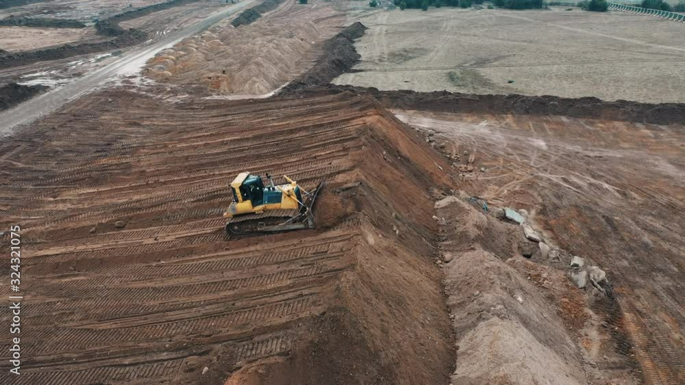Bulldozer digging sand sandy quarry on construction apartment buildings city sleeping area view from top drone on crawler excavator controlled operator preparation of site for apartment high building. Bulldozer digging sand sandy quarry on construction apartment buildings city sleeping area view from top drone on crawler excavator controlled operator preparation of site for apartment high building.