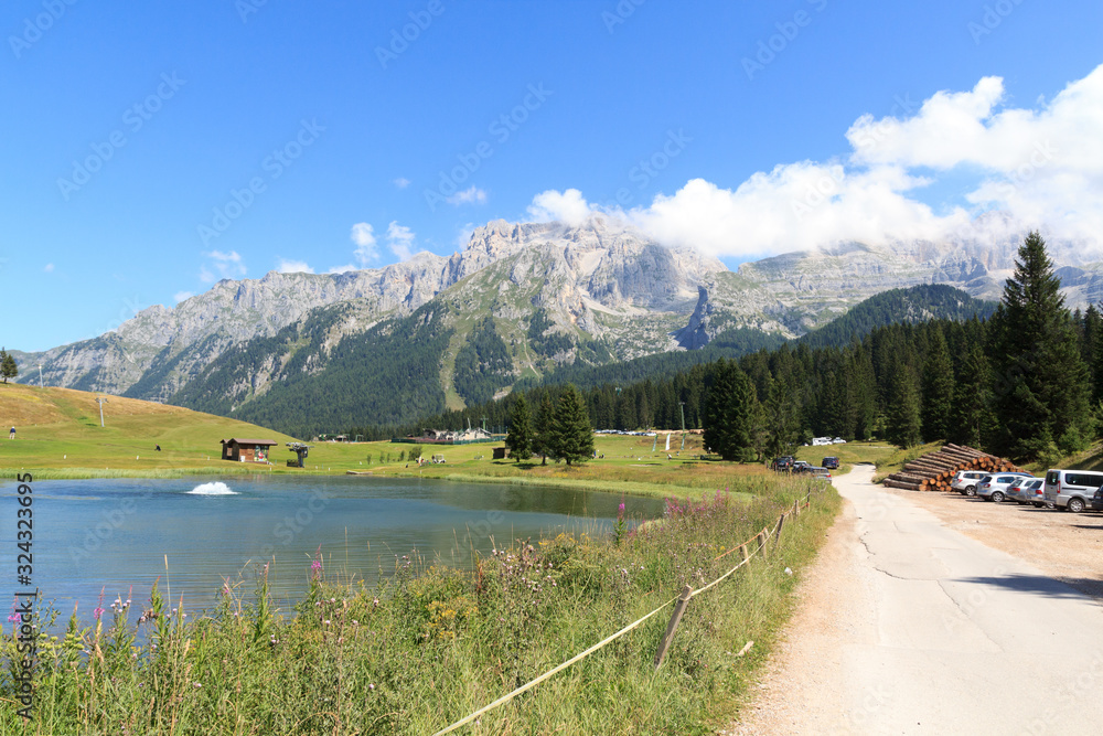Mountain alps panorama of Brenta Dolomites, Golf course and lake in Italy