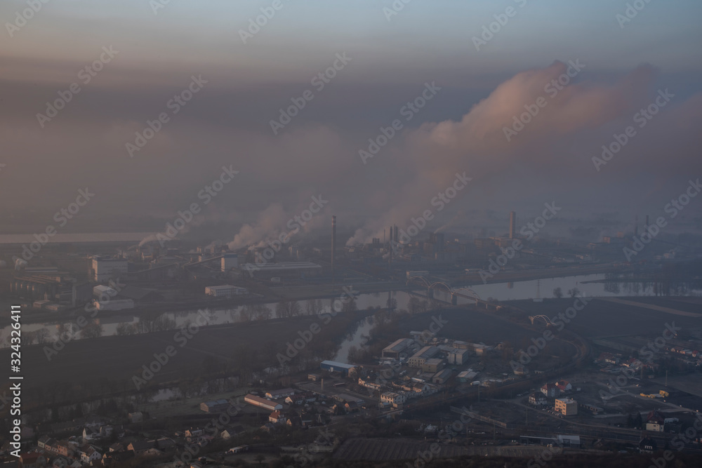 Sunrise time on Radobyl hill over valley of river Labe with big factory