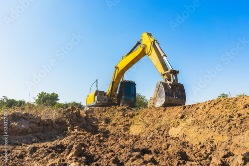 Backhoe digging up soil to prepare agricultural land.