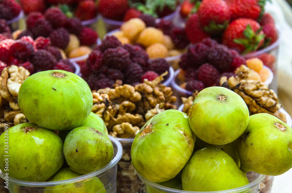 Ripe fruits in glasses for street sale. Jujube, Red and white raspberries, figs, nuts. Travel and adventure. Ripe fruits in glasses for street sale. Jujube, Red and white raspberries, figs, nuts. Travel and adventure.