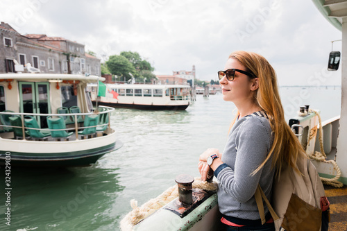 Young female traveler on the tour boat in Venice, Italy