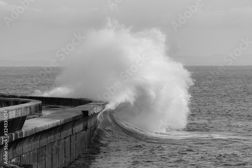 Big ocean wave hitting pier. Storm waves