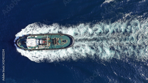 Aerial drone photo of tug assisting boat cruising near commercial container area of Perama, Attica, Greece © aerial-drone