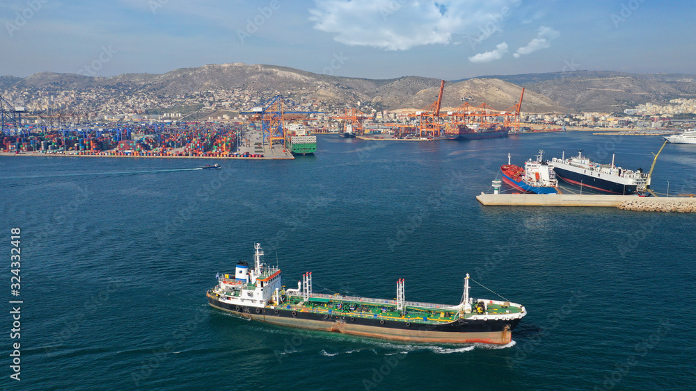 Aerial drone photo of industrial fuel ship cruising near commercial container area of Perama, Attica, Greece
