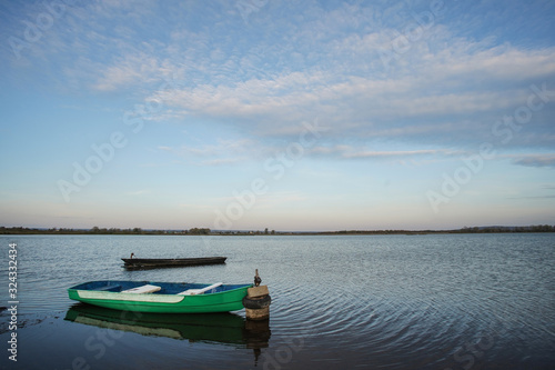  Village boats on the lake. Active sky, ripples in the water. There is free space for text.