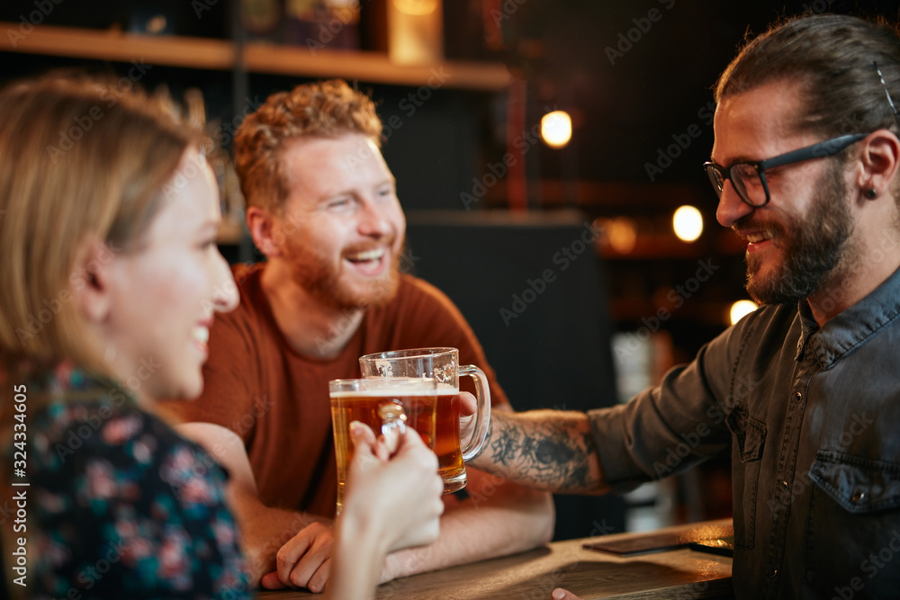 Group of best friends standing at pub and making a toast with beer. Nightlife concept. Group of best friends standing at pub and making a toast with beer. Nightlife concept.