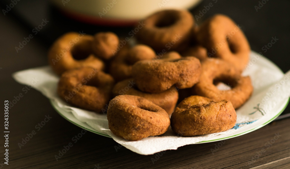 Fat Thursday home preparations - hand made doughnuts fried in deep oil in the kitchen, soaking off fat on the paper towel Fat Thursday home preparations - hand made doughnuts fried in deep oil in the kitchen, soaking off fat on the paper towel